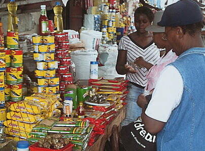 Diese mittellose junge Frau (hinten) in Gonaives (Haiti) erhielt einen kleinen Laden für Nahrungsmittel. Jetzt kann sie angemessen für ihre Familie sorgen